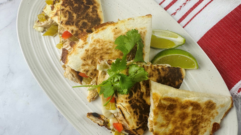 Quesadilla slices on platter with cilantro and lime wedges