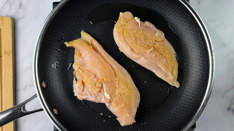 Seasoned chicken breasts in pan