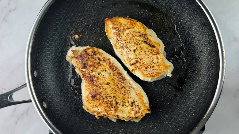 Chicken breasts cooking in pan