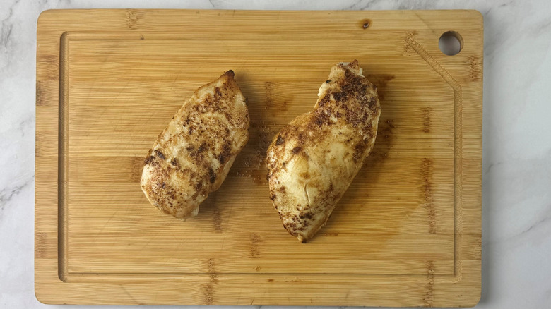 Cooked chicken breasts on cutting board