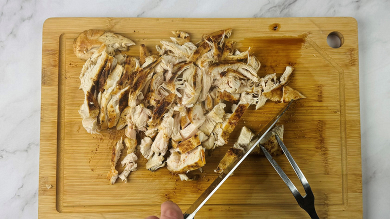 Shredded chicken on cutting board