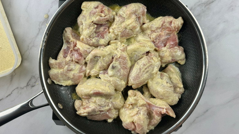 raw chicken in frying pan