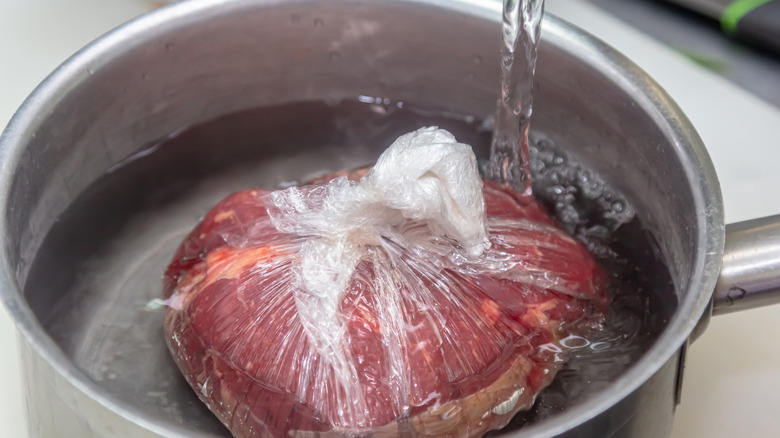 Raw meat in a pan of water