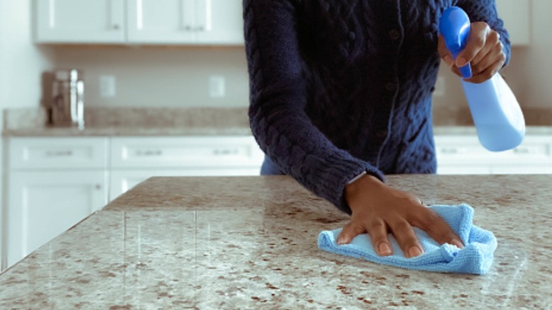 A person cleaning the kitchen counter