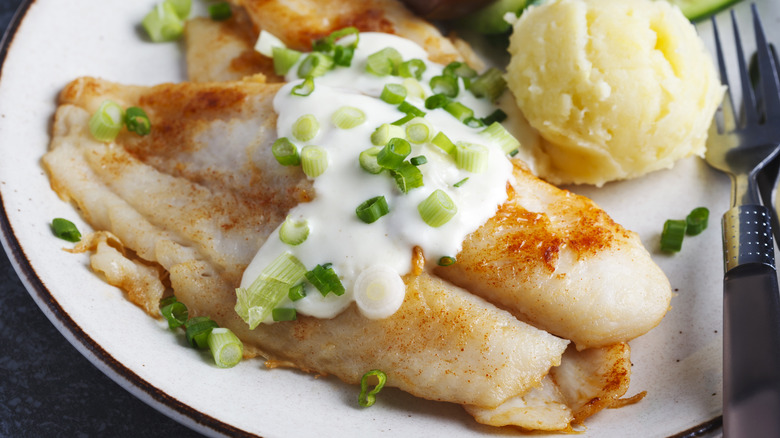 fried basa filet with sauce, mashed potato and fresh vegetables