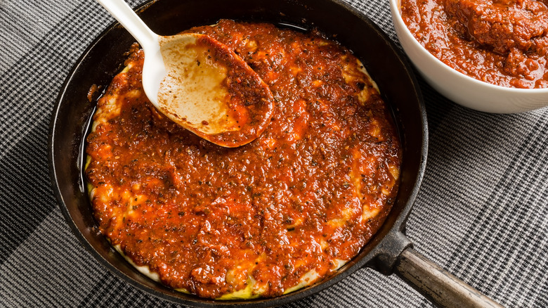 Saucing homemade deep dish pizza