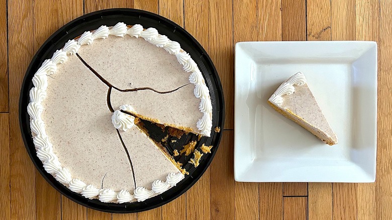 Whole and slice of Pumpkin Cheesecake on white square plate