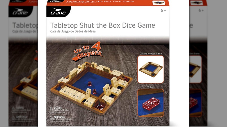 A wooden shut the box dice game inside its original packaging.