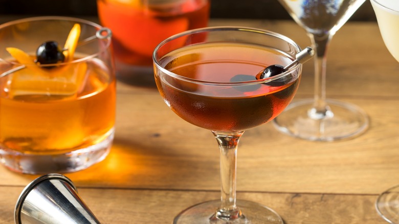 Manhattan, old fashioned, and other cocktails on wood table