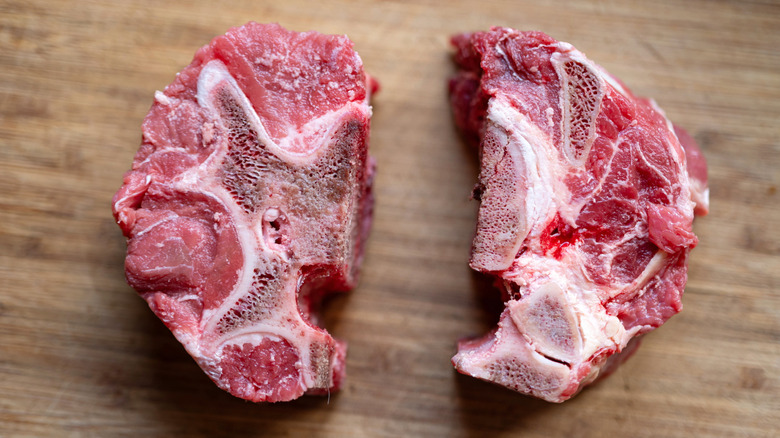 Close up of raw beef neck bone meat on a wooden cutting board