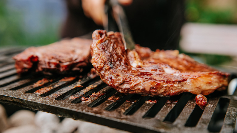 close up of barbecue steaks on a flame grill