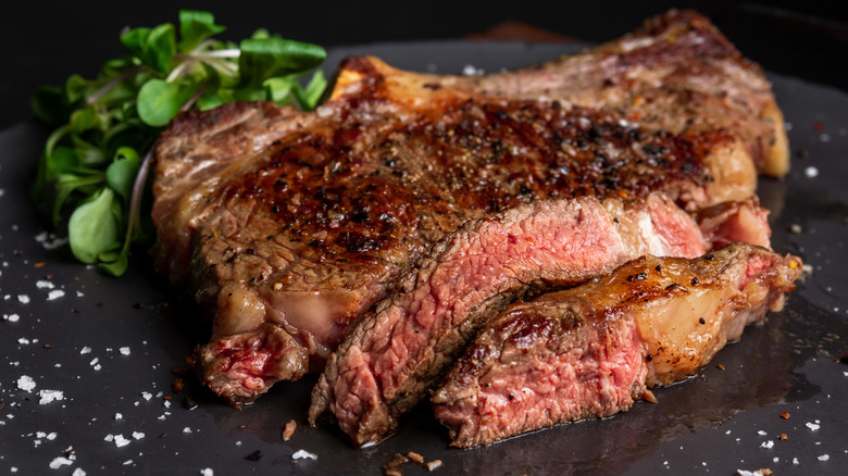 A close-up of sliced medium rare bone in rib eye steak