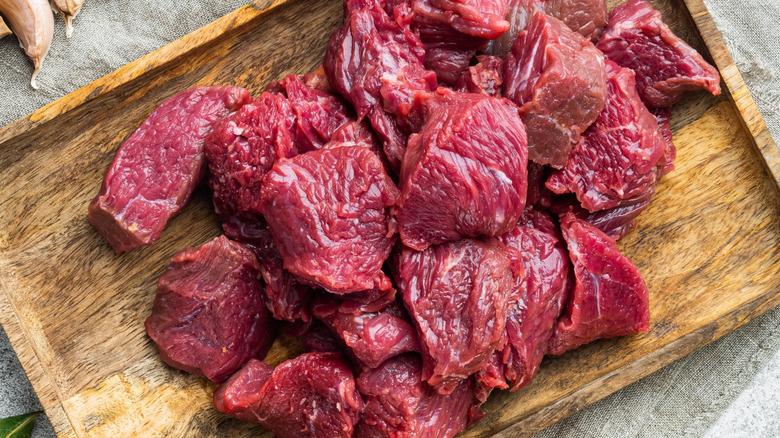 Beef chuck stew ingredients on wood board