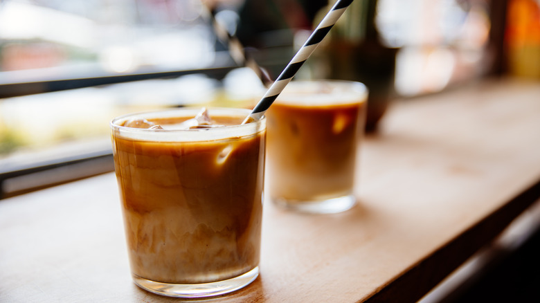 two iced coffees in glasses on a counter