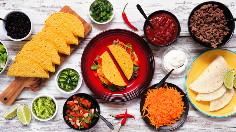 Build-your-own taco bar with ingredients in separate bowls, overhead view.