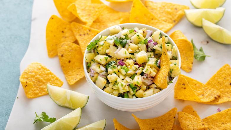 pineapple salsa in a white bowl next to tortilla chips