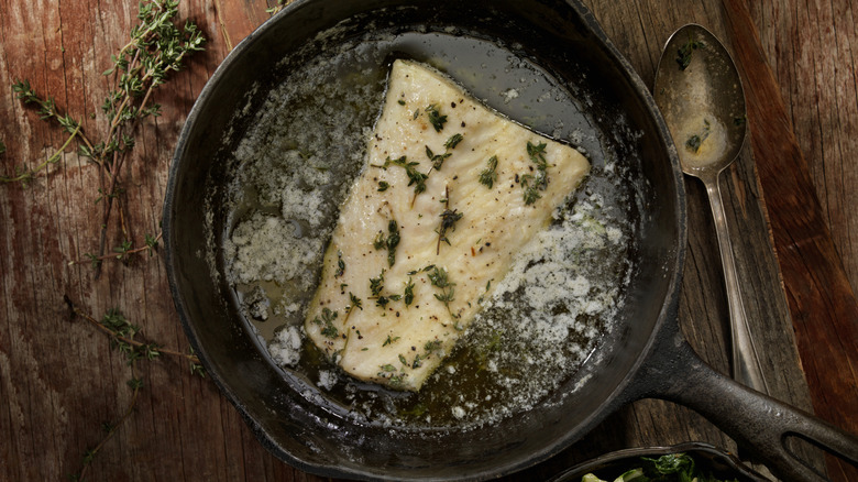 Fish poached in butter in a cast iron skillet