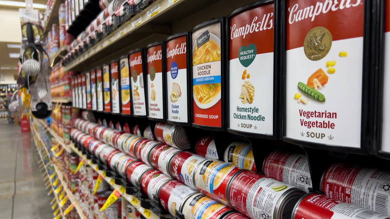 Angled, selective focus on Campbells canned soup products in grocery.