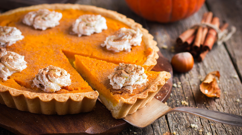 Pumpkin pie with whipped cream and cinnamon