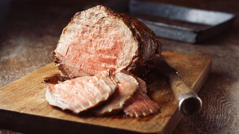 A sliced beef roast on carving board