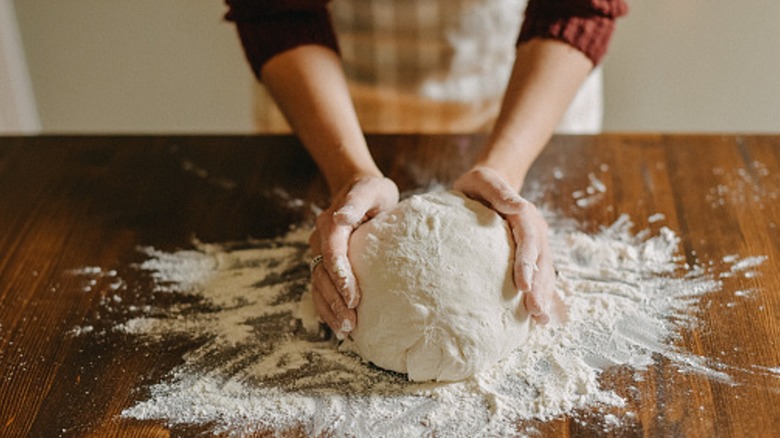 A person kneading bread dough