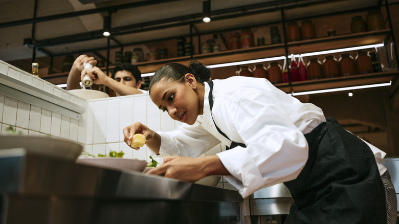 A chef adding the finishing touches to a meal