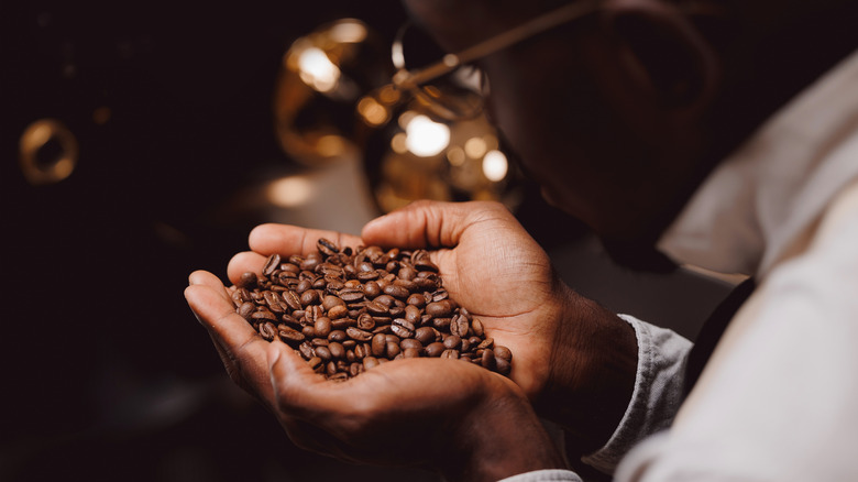 A barista savoring the aroma of coffee beans