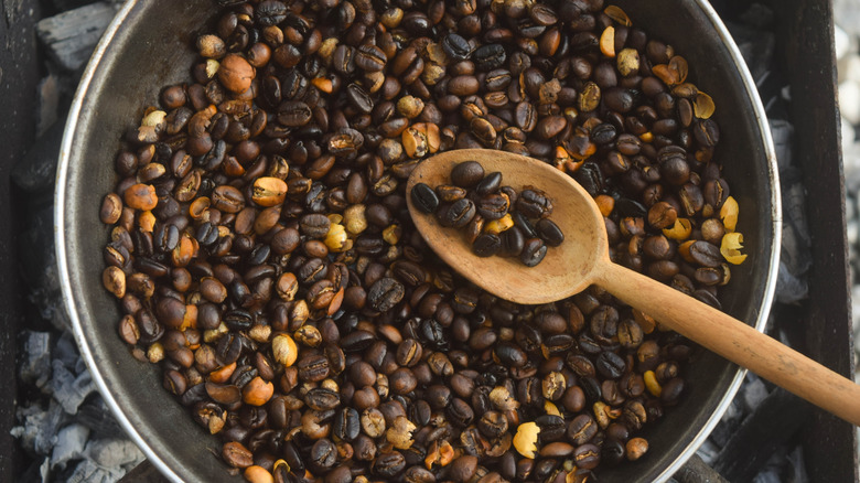 a top-down view of a pan of coffee beans on a burner, being roasted at home