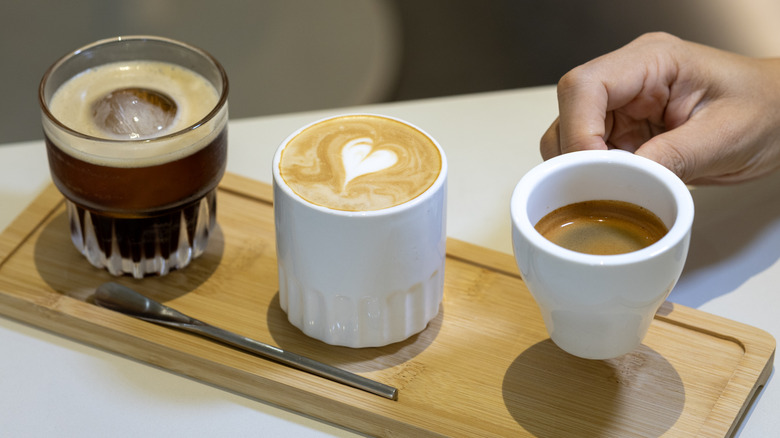 Three different types of coffee on a wooden board