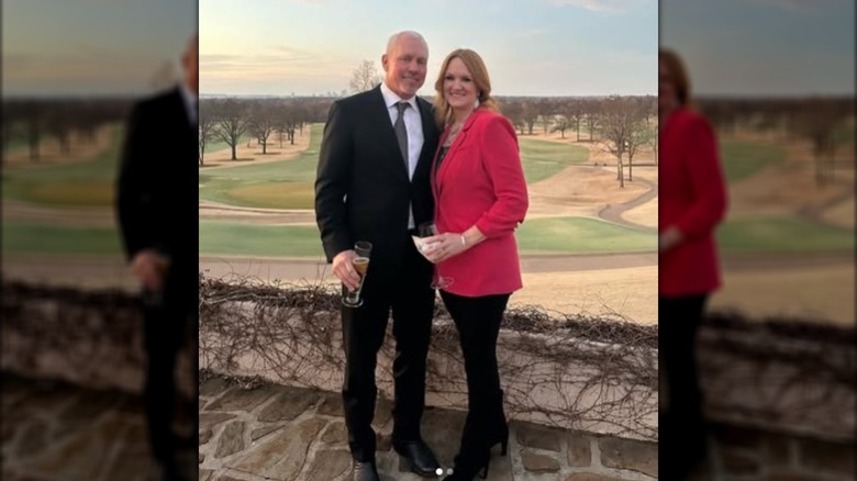 Ladd and Ree Drummond smiling in front of an open field