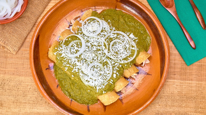 Green mole enchiladas topped with onions