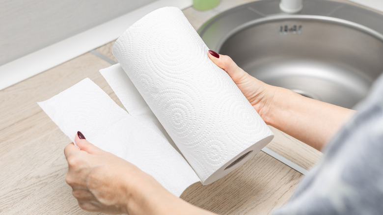 woman's hand ripping off paper towel in kitchen