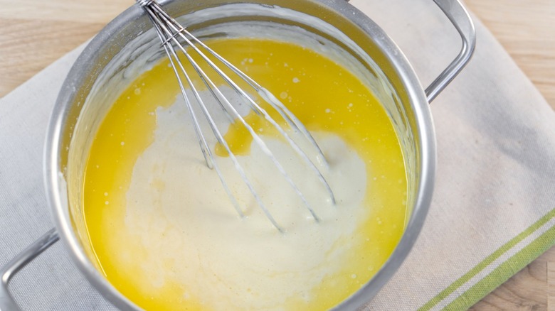 Butter in saucepan with milk and whisk