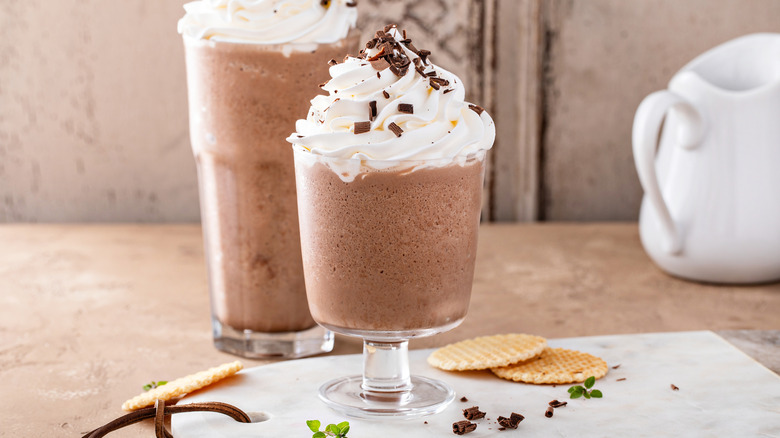 Iced chocolate coffee frappes with whipped cream and chocolate shavings.