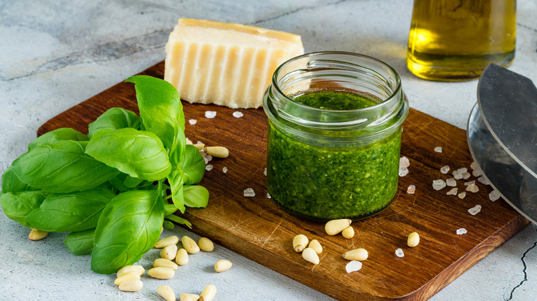 Fresh pesto on a board with basil and Parmesan.