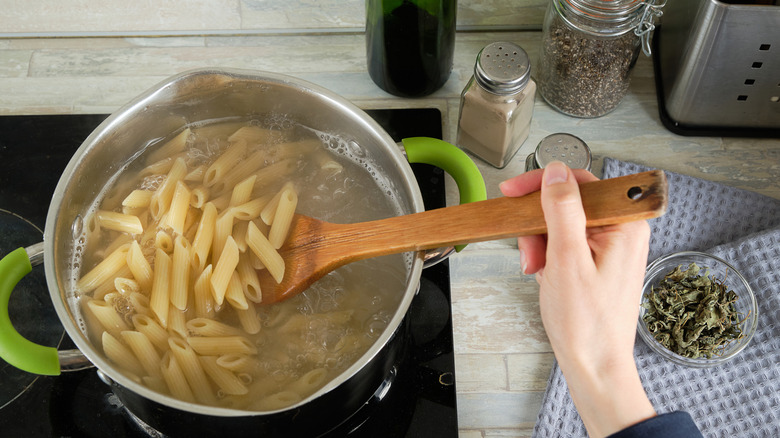 Pasta in pot with wooden spoon