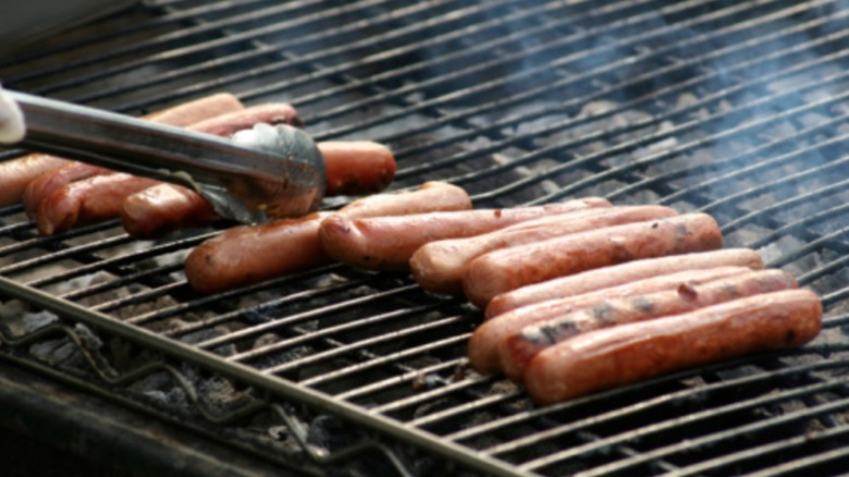 Grabbing hot dogs with tongs