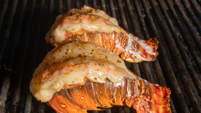 butterflied lobster tails cooking on a grill