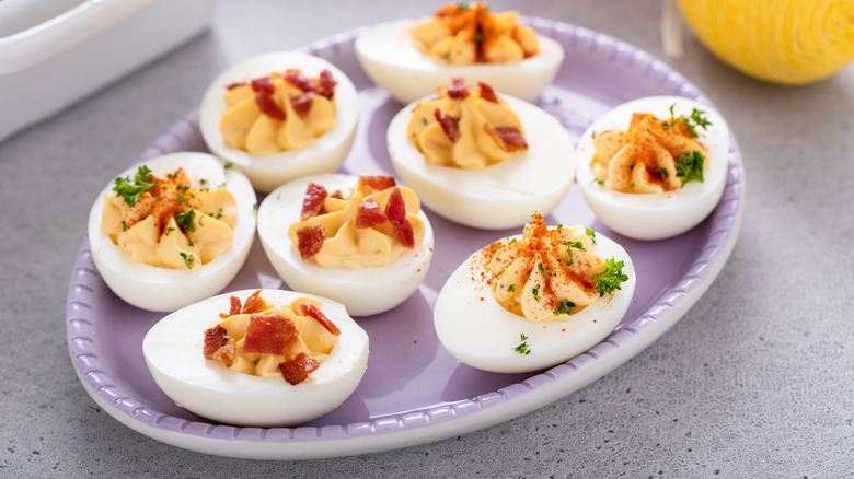 Deviled eggs with bacon and paprika on a plate