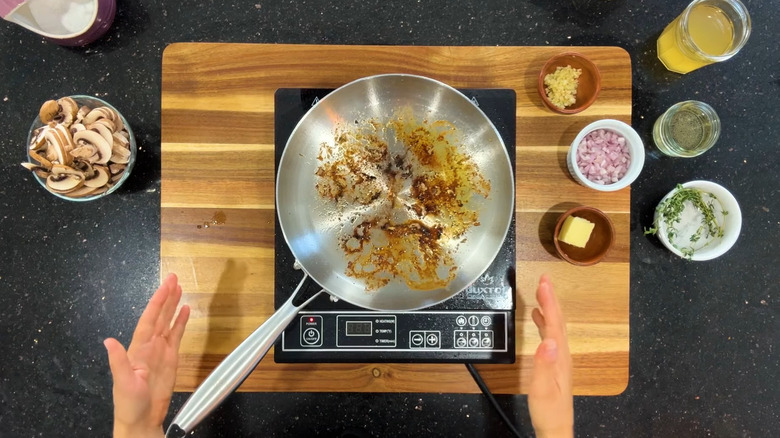 Fond and fat in a stainless steel pan.