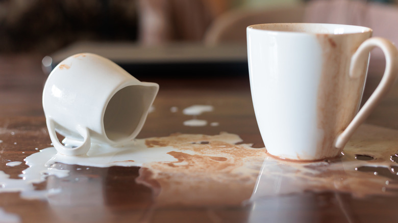 Spilled creamer next to a cup.