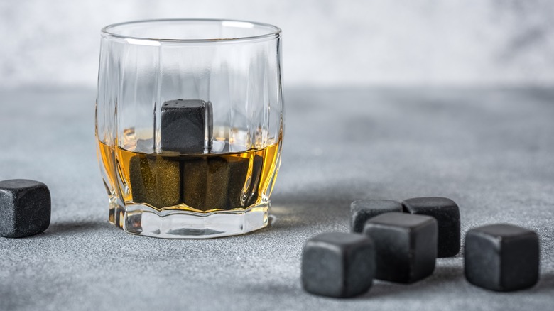 Whiskey with whiskey stones grey background