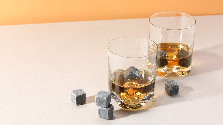 Whiskey stones and liquor in glasses