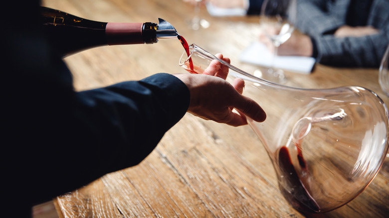 Vintage red wine poured into a decanter