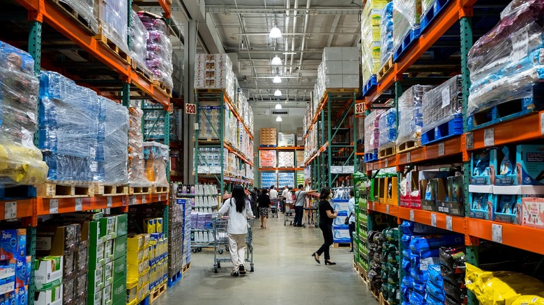 Costco shoppers in long store aisle