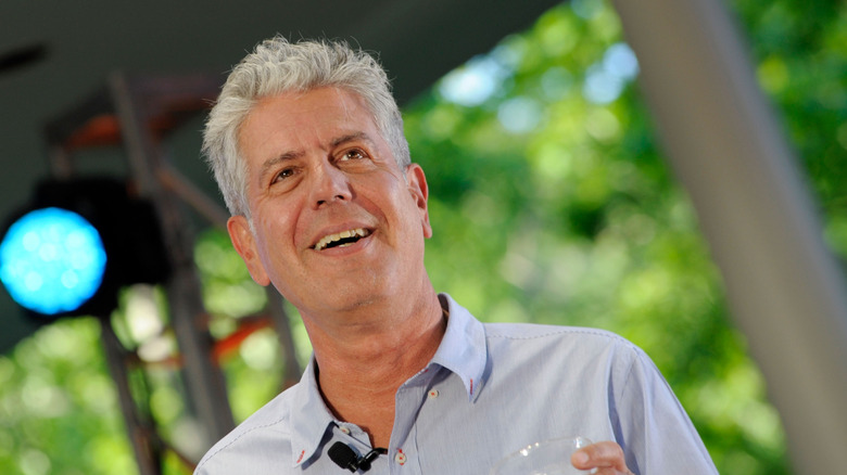 Anthony Bourdain smiling and wearing a pale blue shirt