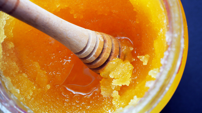 Crystallized honey in jar with honey dipper