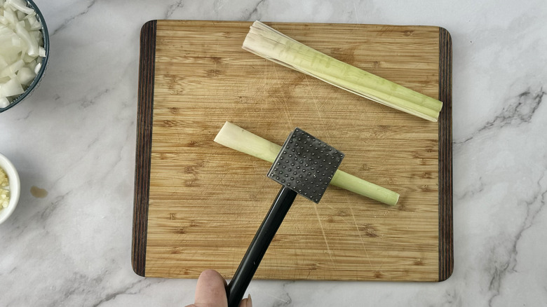 hand hitting lemongrass with mallet