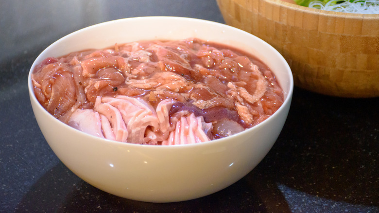 Raw meat marinating in a bowl