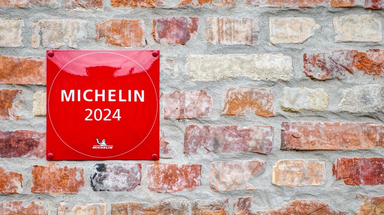 brick wall with a red placard that reads 'Michelin 2024'